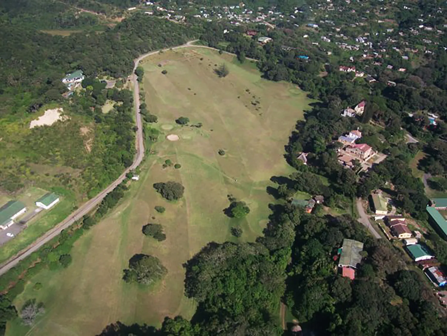 The golf course from above, threading between the trees and the village