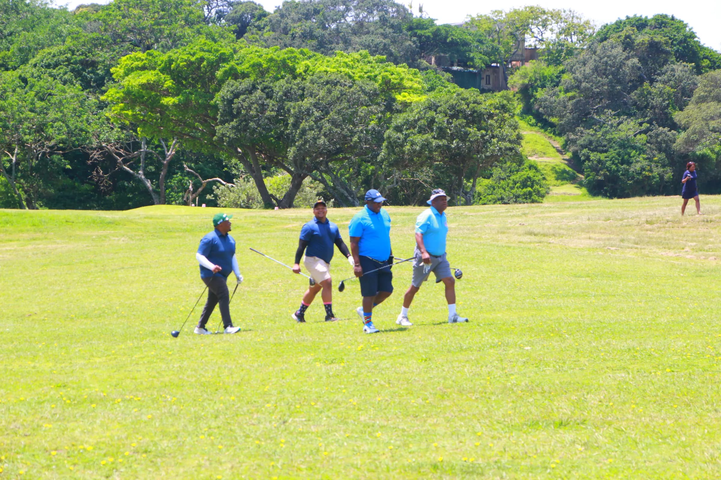 Four golfers walking the fairway together on a club golf day